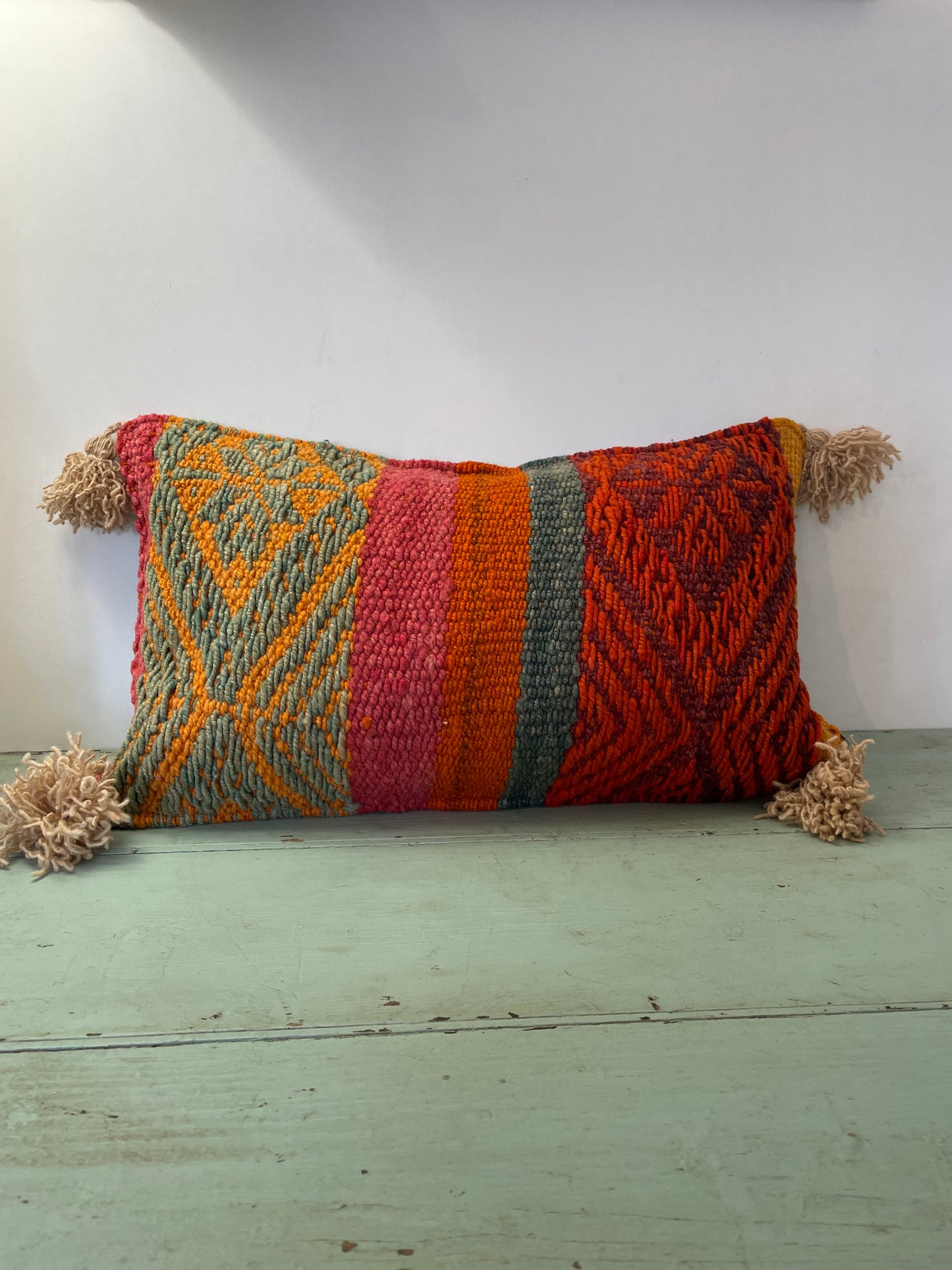 Wool cushion with pom-poms