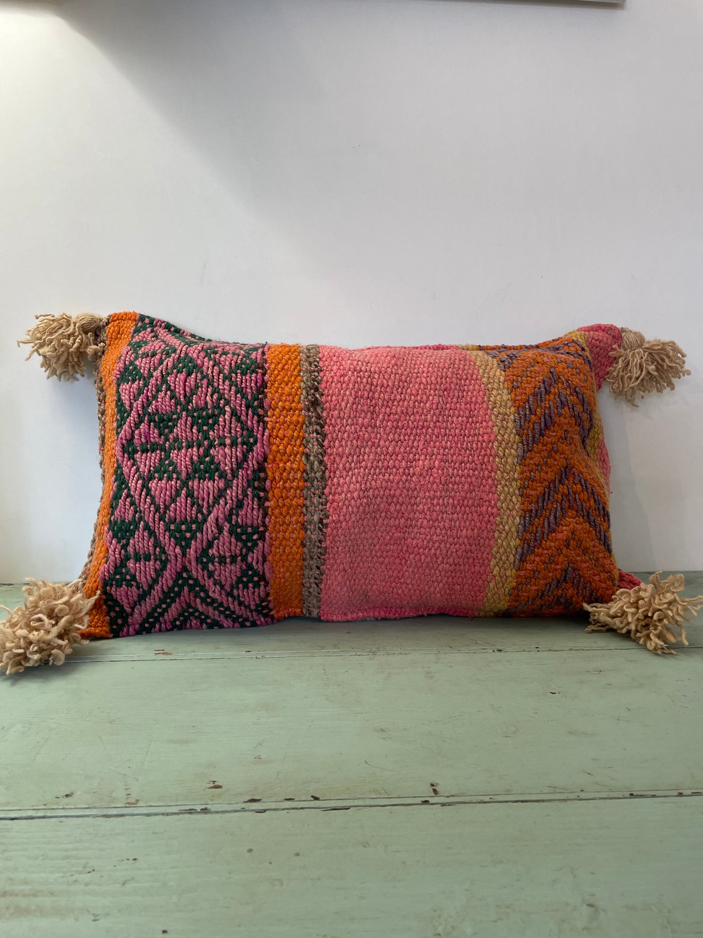 Wool cushion with pom-poms