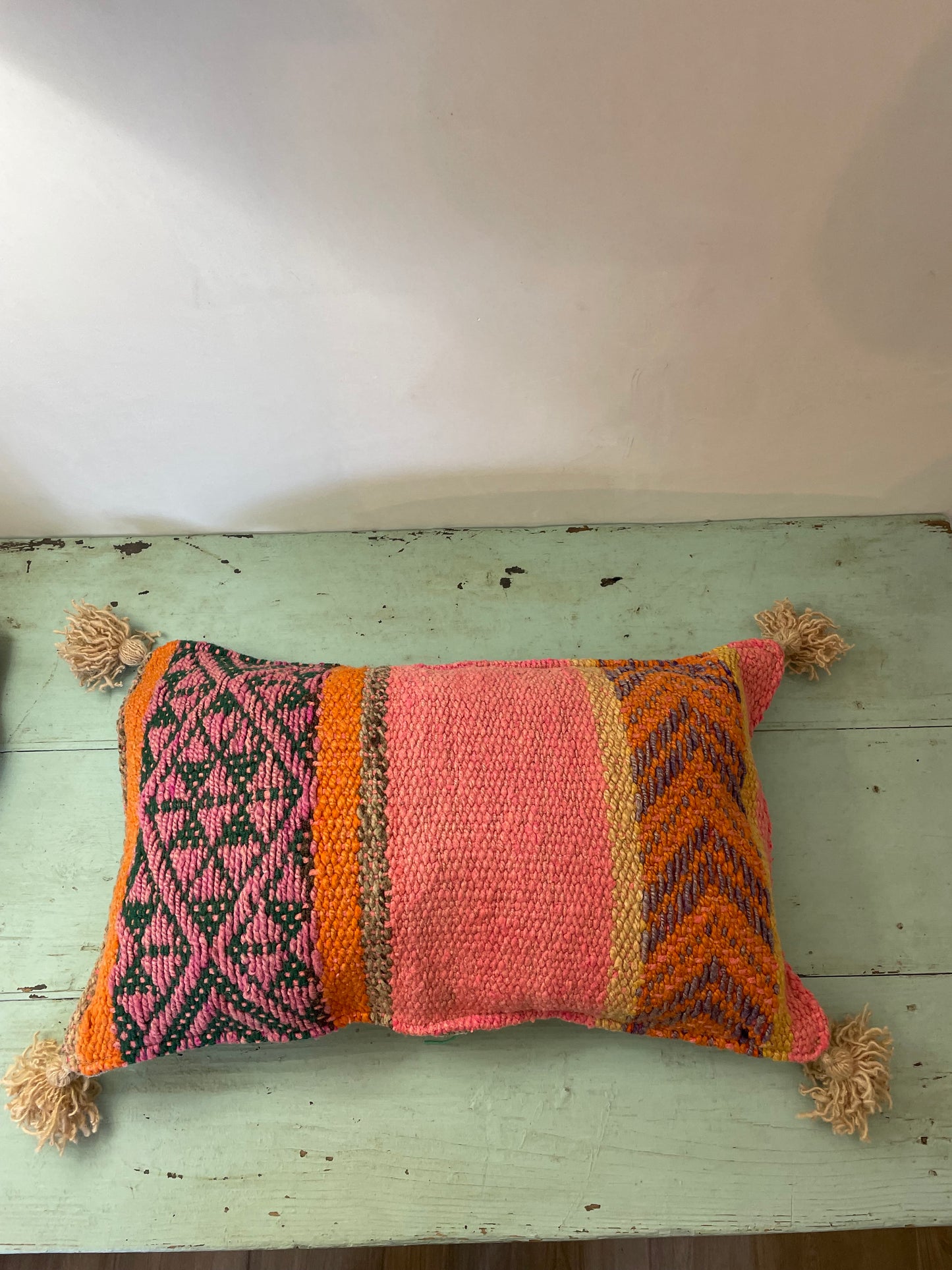 Wool cushion with pom-poms