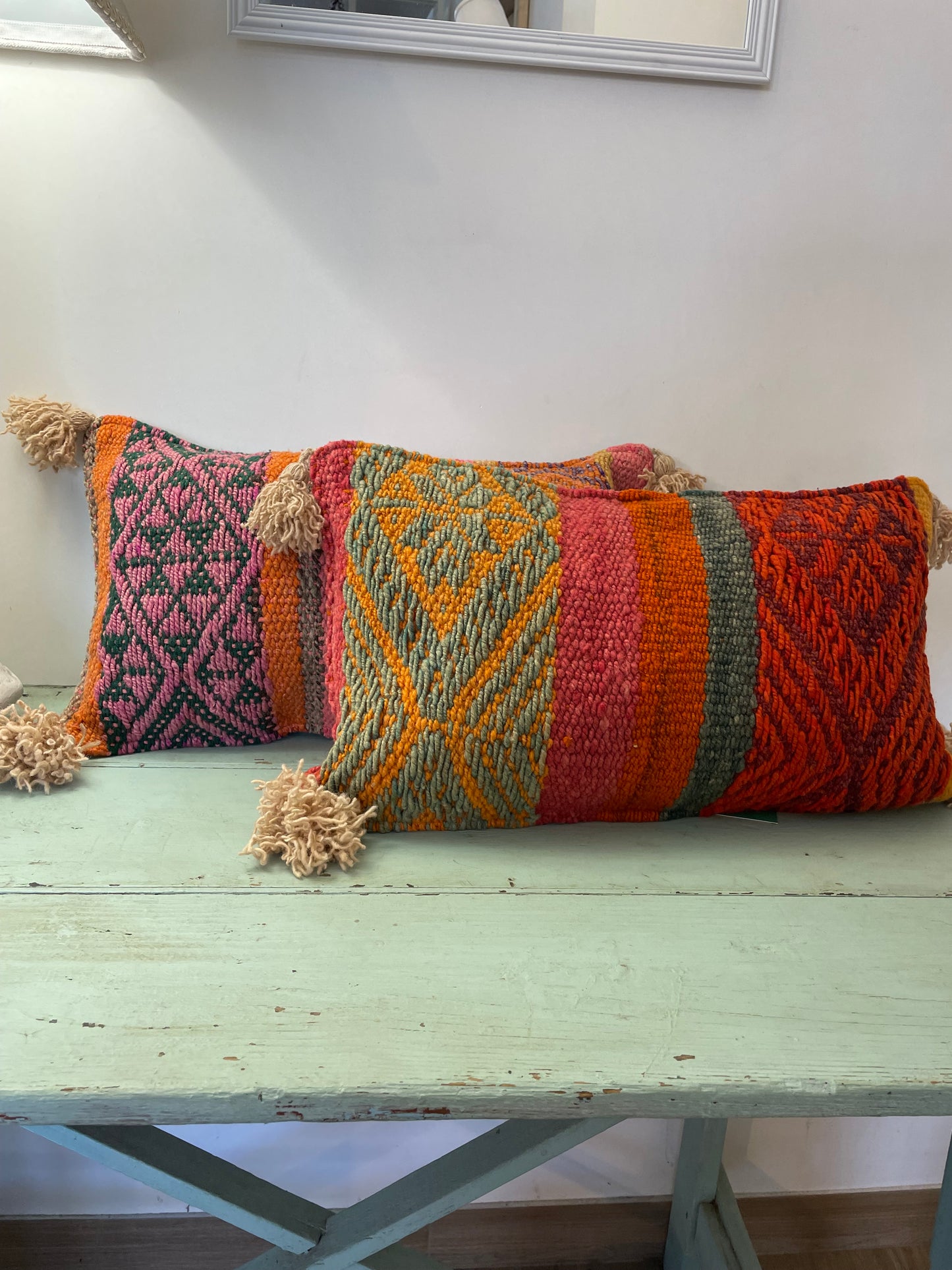 Wool cushion with pom-poms