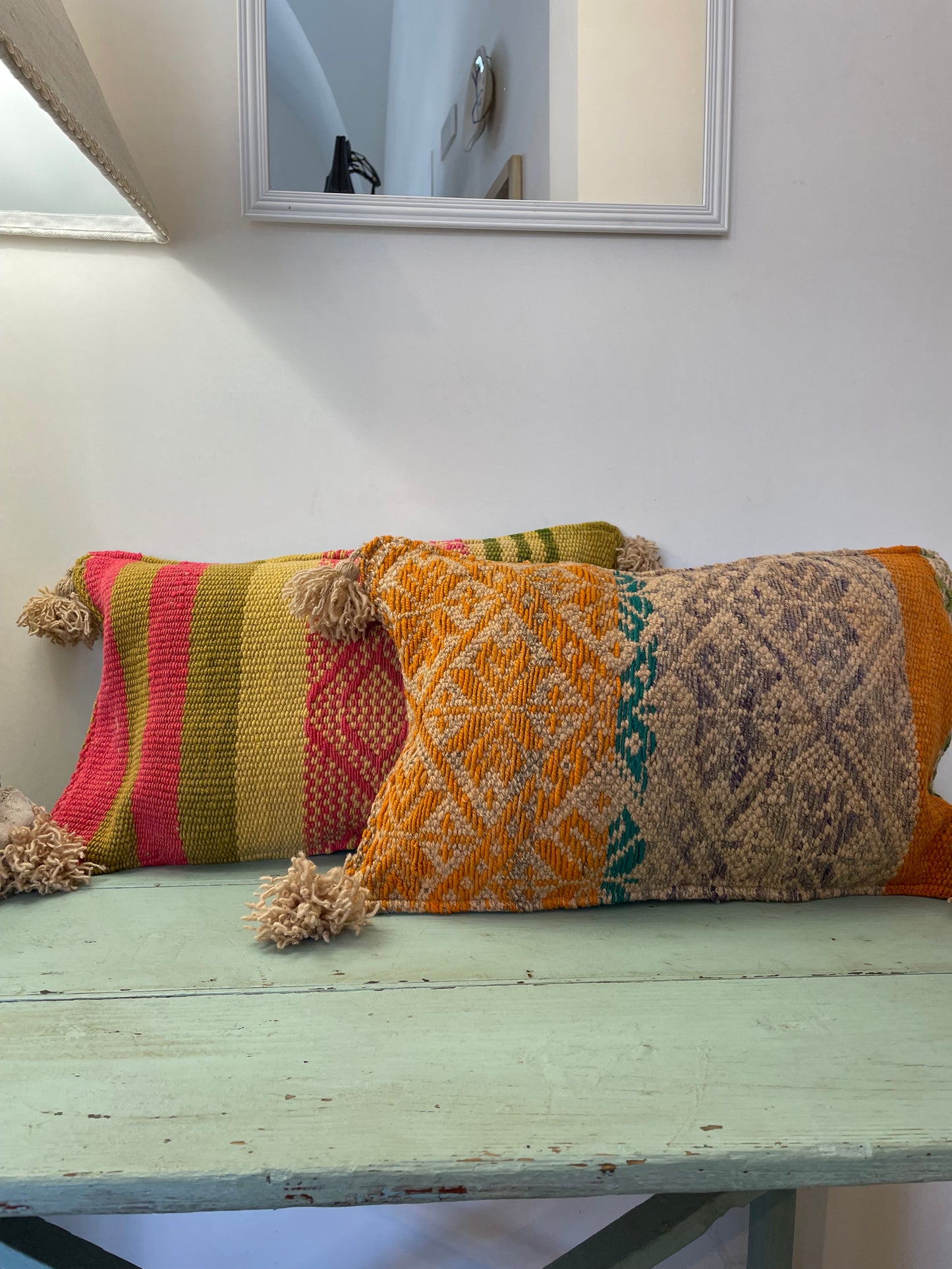 Wool cushion with pom-poms