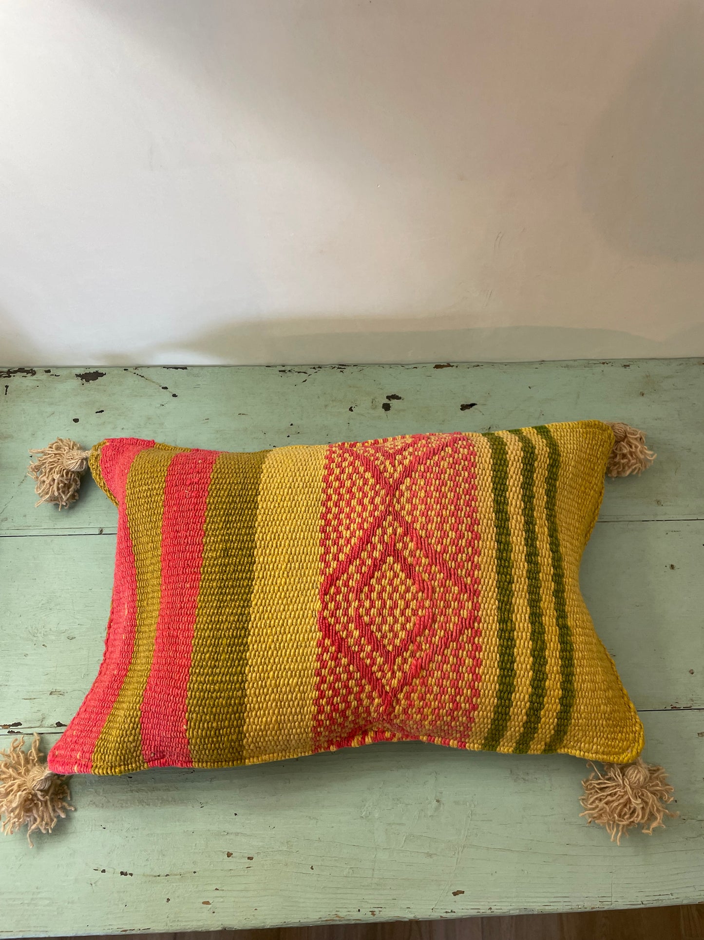 Wool cushion with pom-poms