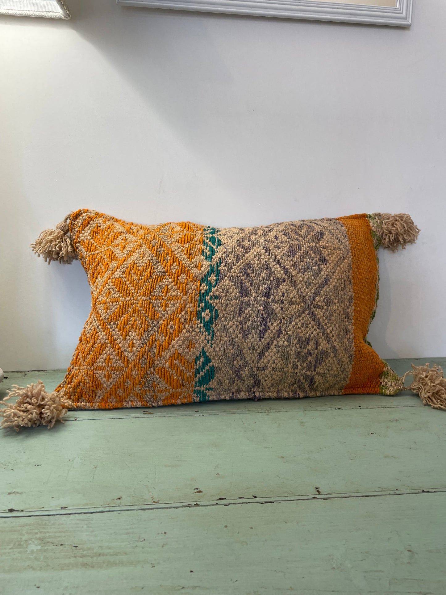 Wool cushion with pom-poms