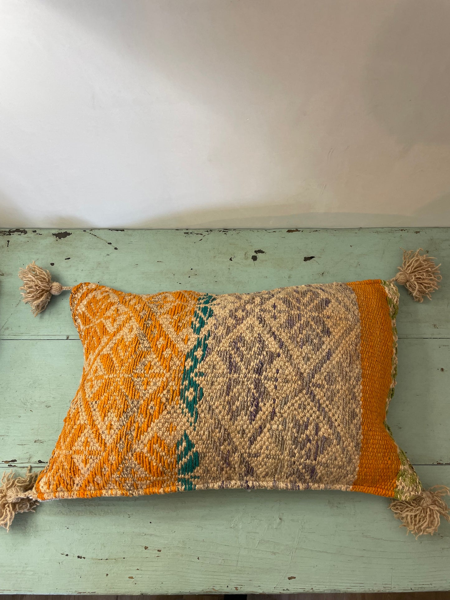 Wool cushion with pom-poms